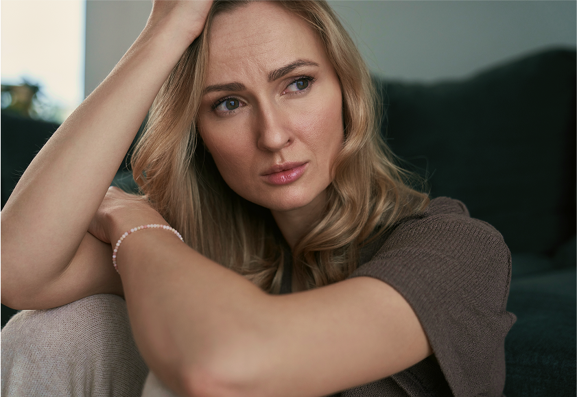 Woman resting her head on her hand with a thoughtful expression