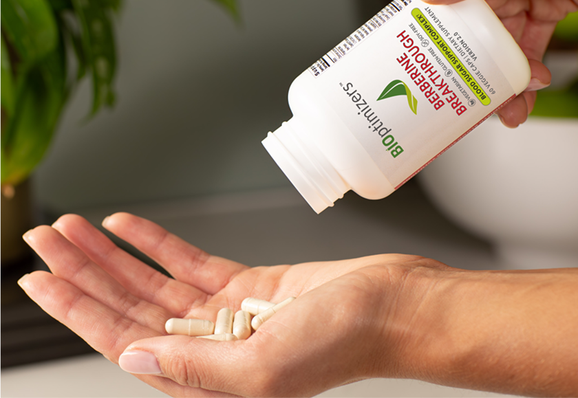 Hand holding Berberine Breakthrough capsules poured from the bottle