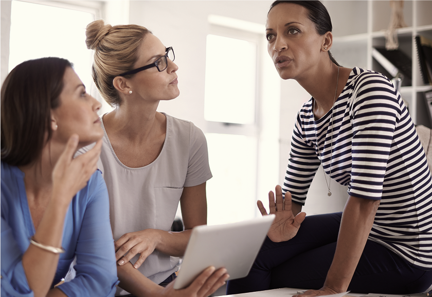 Three women collaborating and looking at a tablet together